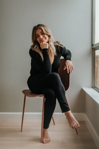 a woman sitting on a chair in front of a window