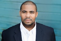 a black man wearing a suit and white shirt